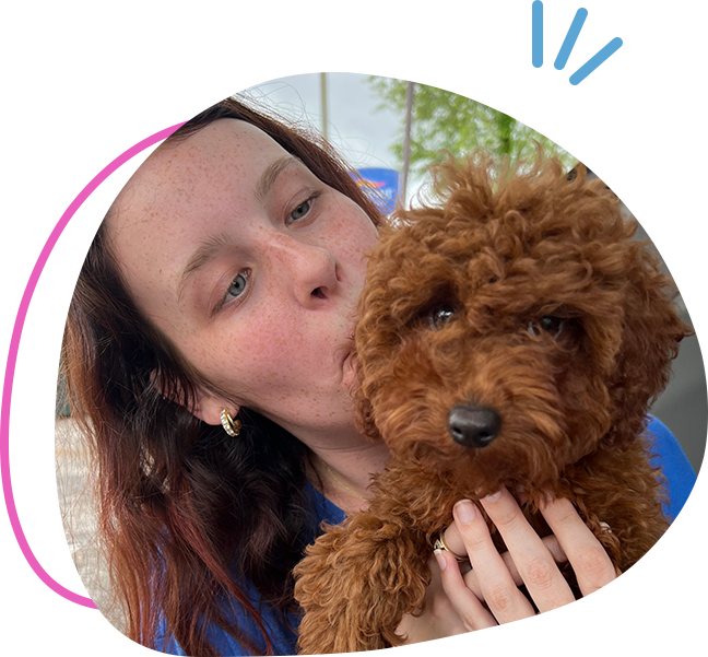 A woman holding a brown dog in her arms.